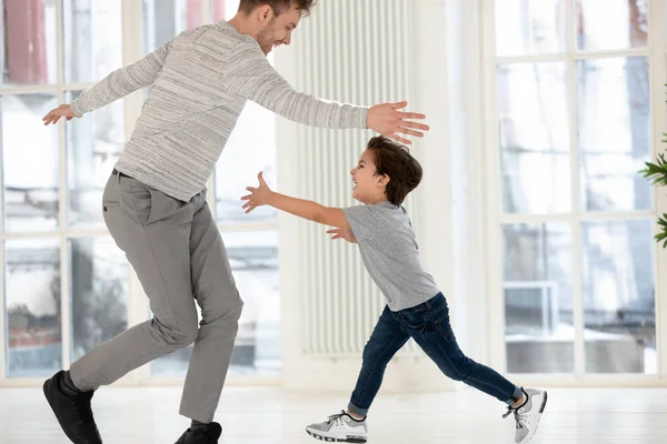 Счастливый отец и сын веселятся, играя в гостиной — стоковое фото
