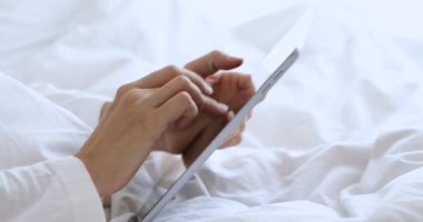 Yatakta tablet bilgisayar kullanan kadın, görüntüyü kapat