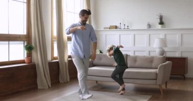 Neşeli çılgın baba ve tatlı çocuk dans ederken eğleniyorlar.