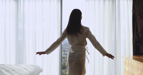 Donna felice che gira con le braccia distese da sola in camera da letto — Video Stock