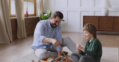 Sevgi dolu küçük baba ve çocuk evde oyuncak oynuyor.