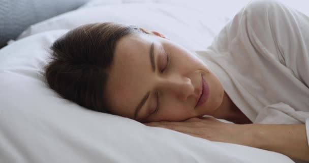 Gesunde attraktive Dame schläft mit geschlossenen Augen im gemütlichen Bett — Stockvideo