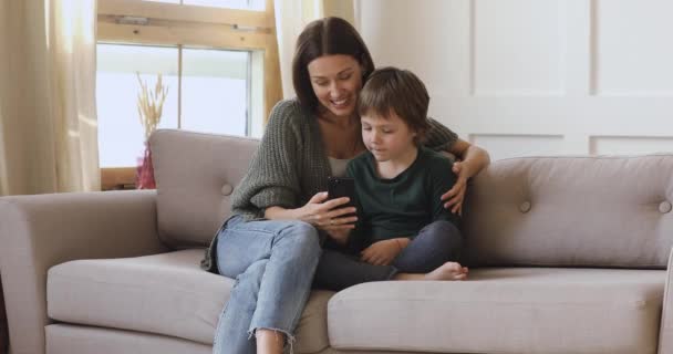 Happy mum teaching kid son learning using smartphone apps — Stock Video