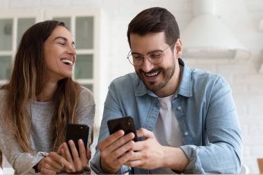 Akıllı telefon kullanan neşeli bir çift mobil oyunlar oynuyor.