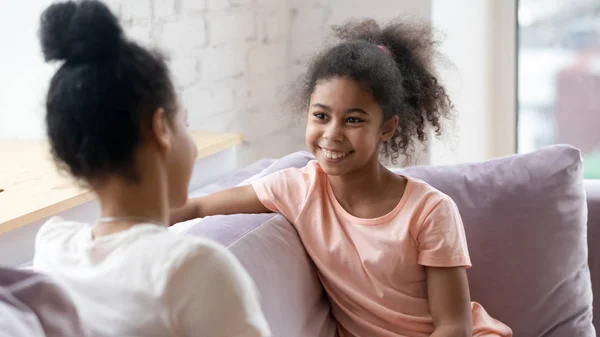 Glimlachend meisje praten delen geheim met moeder — Stockfoto