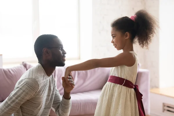 Afro-americano papá arrodillarse beso mano de biracial hija —  Fotos de Stock