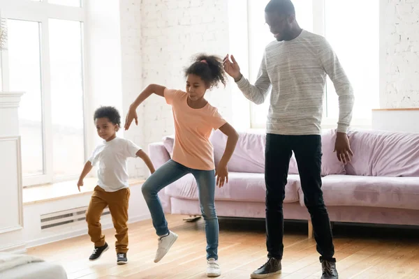 Gelukkig afrikaans amerikaanse vader veel plezier dansen met kinderen — Stockfoto