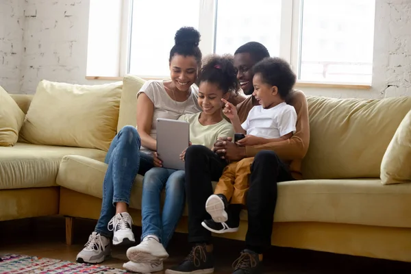 Çocuklarla mutlu çift ırklı aile tablet kullanarak iyi eğlenceler. — Stok fotoğraf