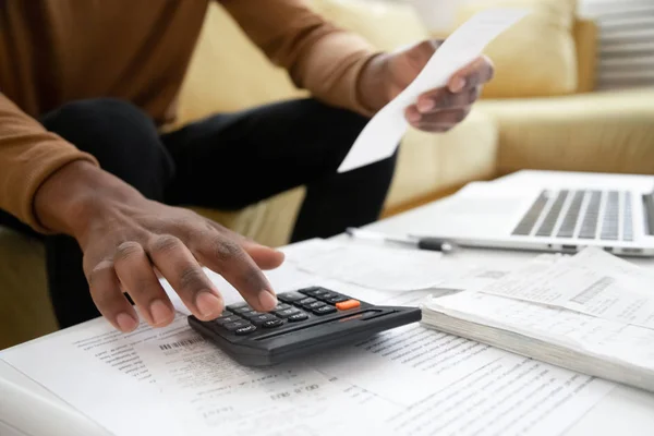 Africano americano homem calculando em despesas de contabilidade máquina — Fotografia de Stock