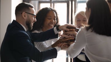 Mutlu melez ırk olgun ve genç iş arkadaşları el ele tutuşuyor..