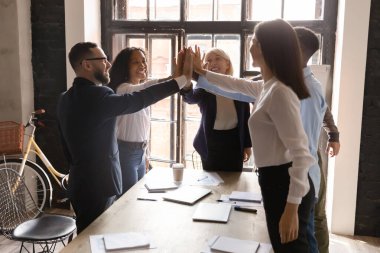 Neşeli, coşkulu, çeşitli iş insanları havada el ele tutuşuyor..