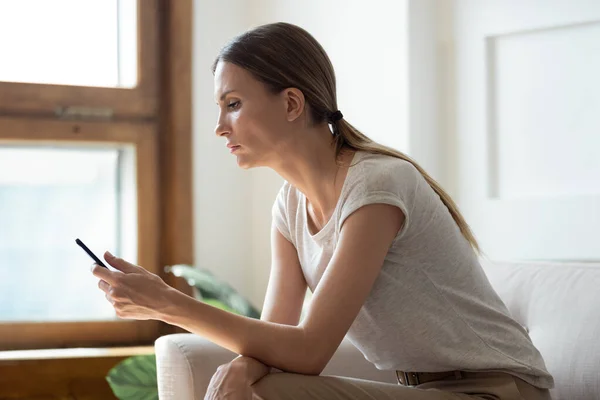 Ragazza premurosa che guarda lo schermo del telefono cellulare . — Foto Stock