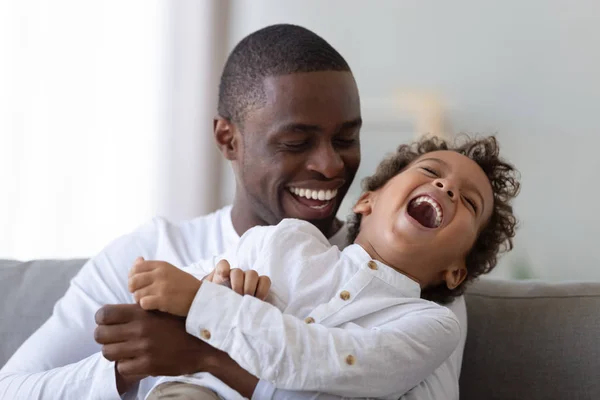 Feliz afro-americano milenar pai cócegas rindo filho . — Fotografia de Stock