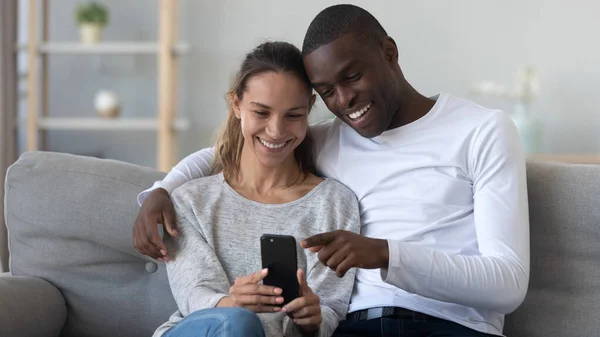 快乐的年轻的混血家庭夫妇使用手机. — 图库照片
