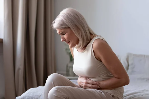 Velha mulher insalubre sofre de dor intensa dor abdominal — Fotografia de Stock