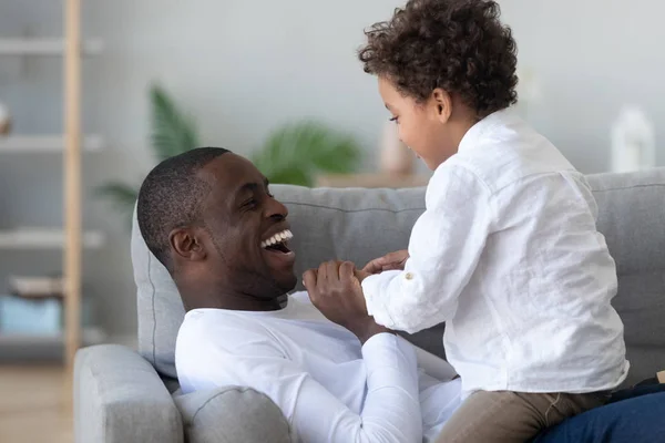 Lleno de alegría afroamericano hombre jugando con poco lindo hijo . —  Fotos de Stock