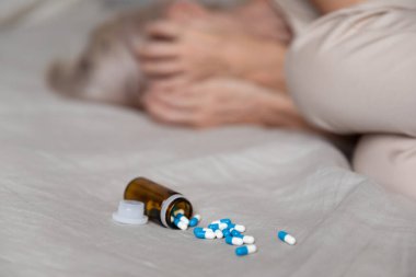 Bunalımlı kadın yatakta uzanıp ağlıyor. Yakın plan haplara odaklanıyor.