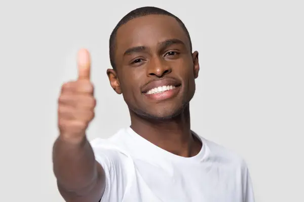 Tæt på smilende glad afrikansk amerikansk mand viser tommelfingre op - Stock-foto