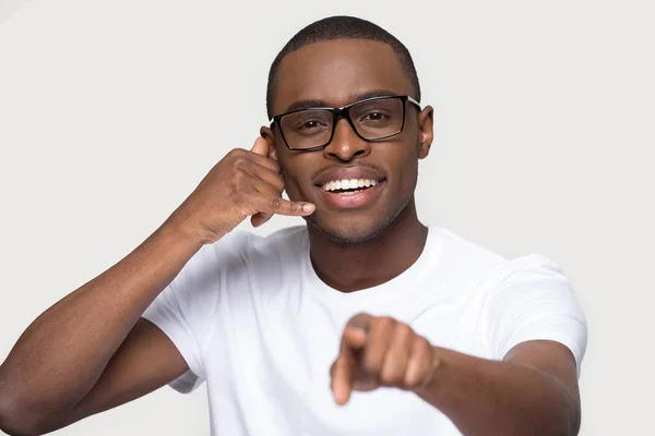 Улыбающийся афроамериканец в очках зовет меня жестом — стоковое фото