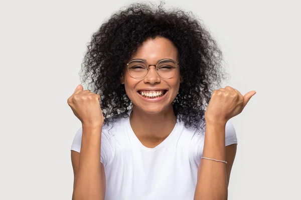 Excited smiling African American woman in glasses celebrating win — Stock Photo, Image
