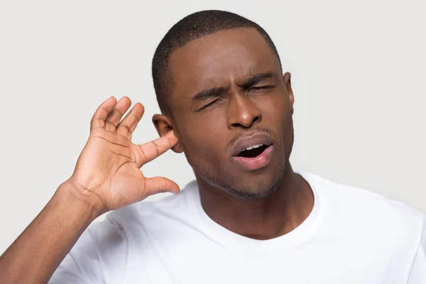 Несчастный афроамериканец воткнул палец в ухо, чувствуя боль — стоковое фото