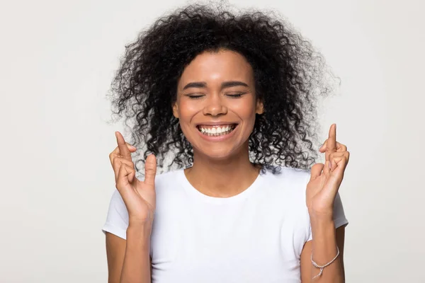 Sorridente donna afroamericana incrociando le dita augurando buona fortuna — Foto Stock