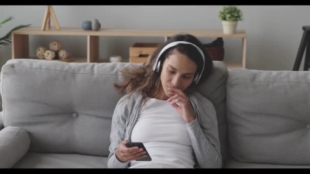 Glad ung blandras kvinna lyssnar på musik i hörlurar. — Stockvideo