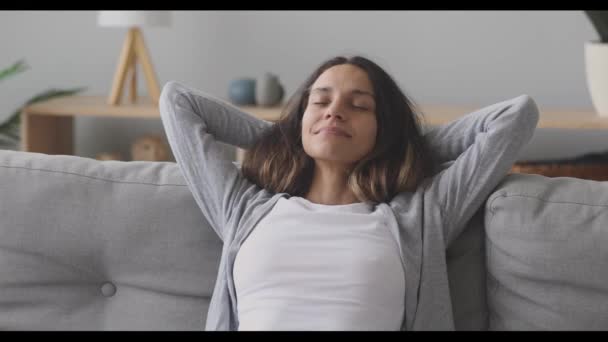 Šťastný klidný tisíciletá žena relaxuje na pohodlném gauči. — Stock video