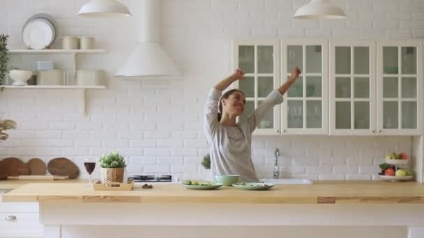 Despreocupado feliz joven mujer bailando solo cocina comida en la cocina — Vídeos de Stock