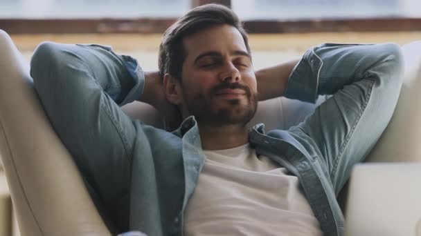 Lugn glad frisk ung man vilar andas på bekväm fåtölj — Stockvideo