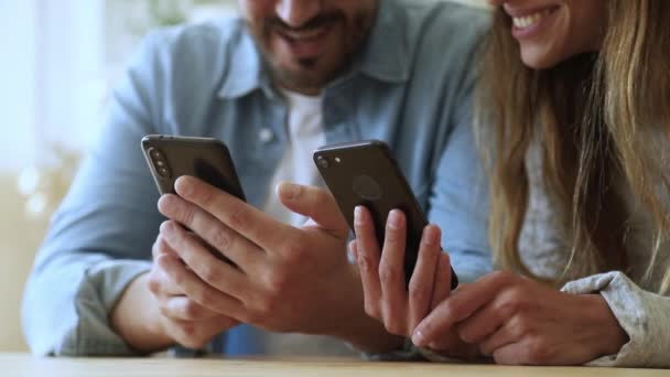 스마트폰 앱을 사용하여 웃고 이야기하는 젊은 커플, 가까이 보기 — 비디오