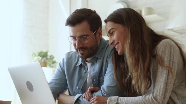 Szczęśliwa młoda rodzina para rozmawia bonding śmiejąc się za pomocą laptopa — Wideo stockowe