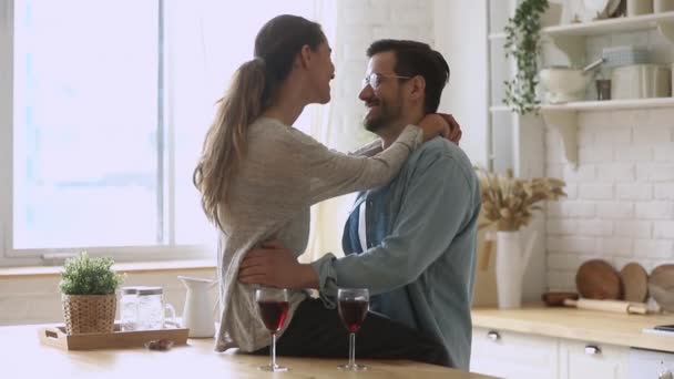 Счастливая романтическая молодая пара разговаривает обнимаясь на кухне — стоковое видео