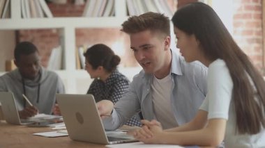 İlgili Asyalı meslektaşına eğitim materyallerini açıklayan genç adam..