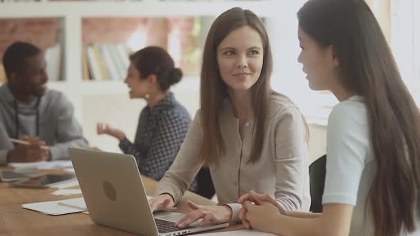 Aangenaam Kaukasisch meisje werken op computer met Vietnamese vriend. — Stockvideo