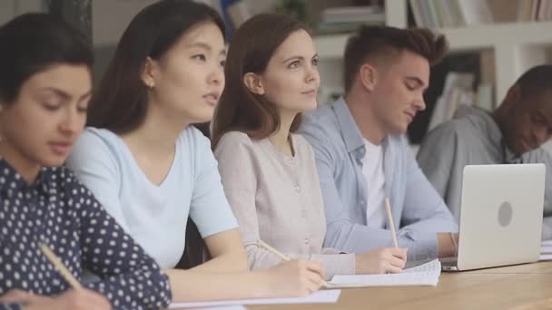 Blandade rasgruppskamrater som sitter på pedagogiska föredrag. — Stockvideo