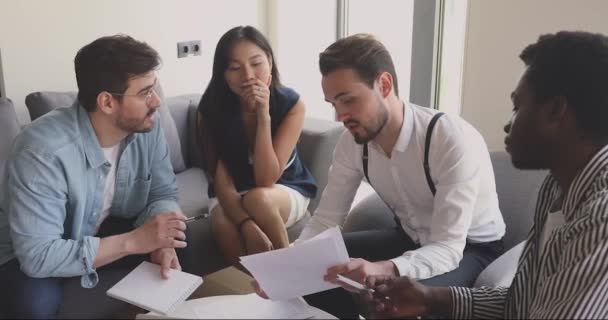 Feliz centrado jóvenes empleados de raza mixta discutir informes de papel . — Vídeo de stock