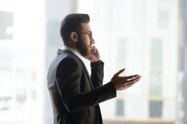 Genç Arap işadamı ofiste cep telefonuyla konuşuyor.