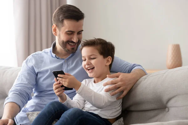 Laughing father and son using smartphone having fun in internet — Stock Photo, Image