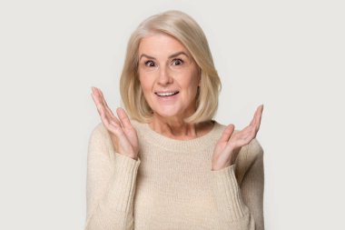 Şaşırmış yaşlı bir kadının samimi şaşkınlık duyguları gösteren bir fotoğrafı.