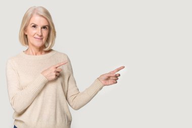 Mutlu yaşlı kadın boşluğa boşluğu gösteriyor