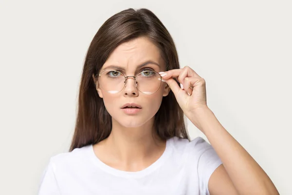 Escéptica mujer morena milenaria gafas inferiores como signo de confusión — Foto de Stock