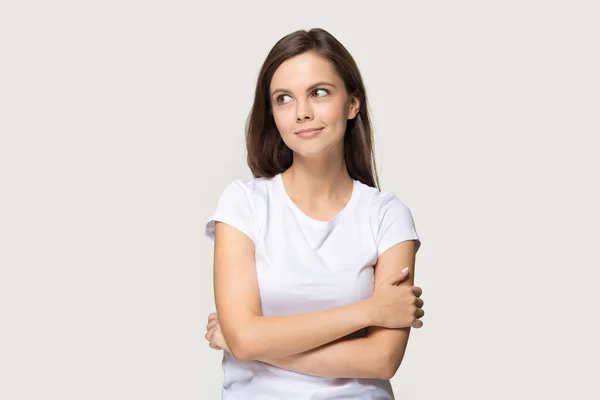 Happy smiling millennial woman looking aside holding her arms crossed — Stock Photo, Image