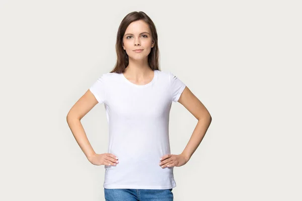 Portrait of millennial woman demonstrating white t-shirt for copyspace — ストック写真