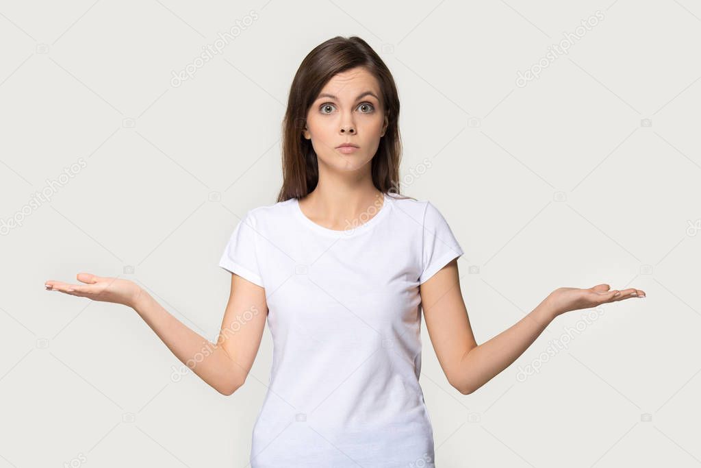 Confused young woman shrug as sign of doubt making choice