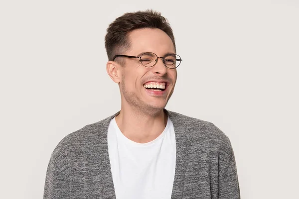 Happy young man laughing at funny joke squinting his eyes — Stock Photo, Image