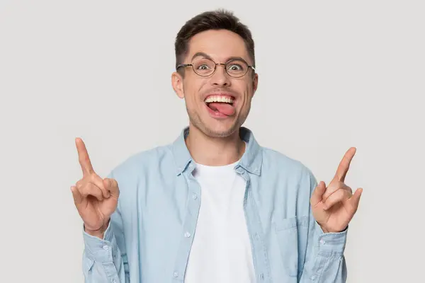 Funny crazy man showing rock-n-roll gesture with sticked out tongue. — Stock Photo, Image