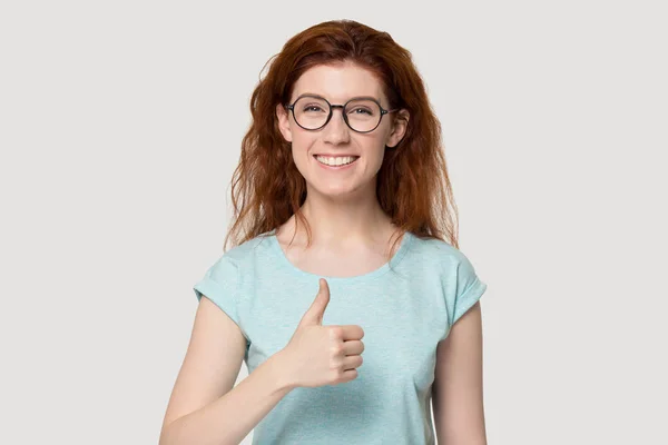 Młoda uśmiechnięta kobieta pokazuje kciuki w górę gest. — Zdjęcie stockowe