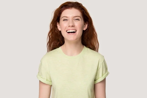 Tête tournée en studio portrait souriant femme aux cheveux roux, riant à la blague . — Photo