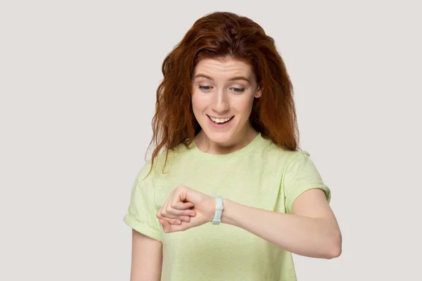 Happy smiling red-haired woman looking at new wrist watch. — Stock Photo, Image